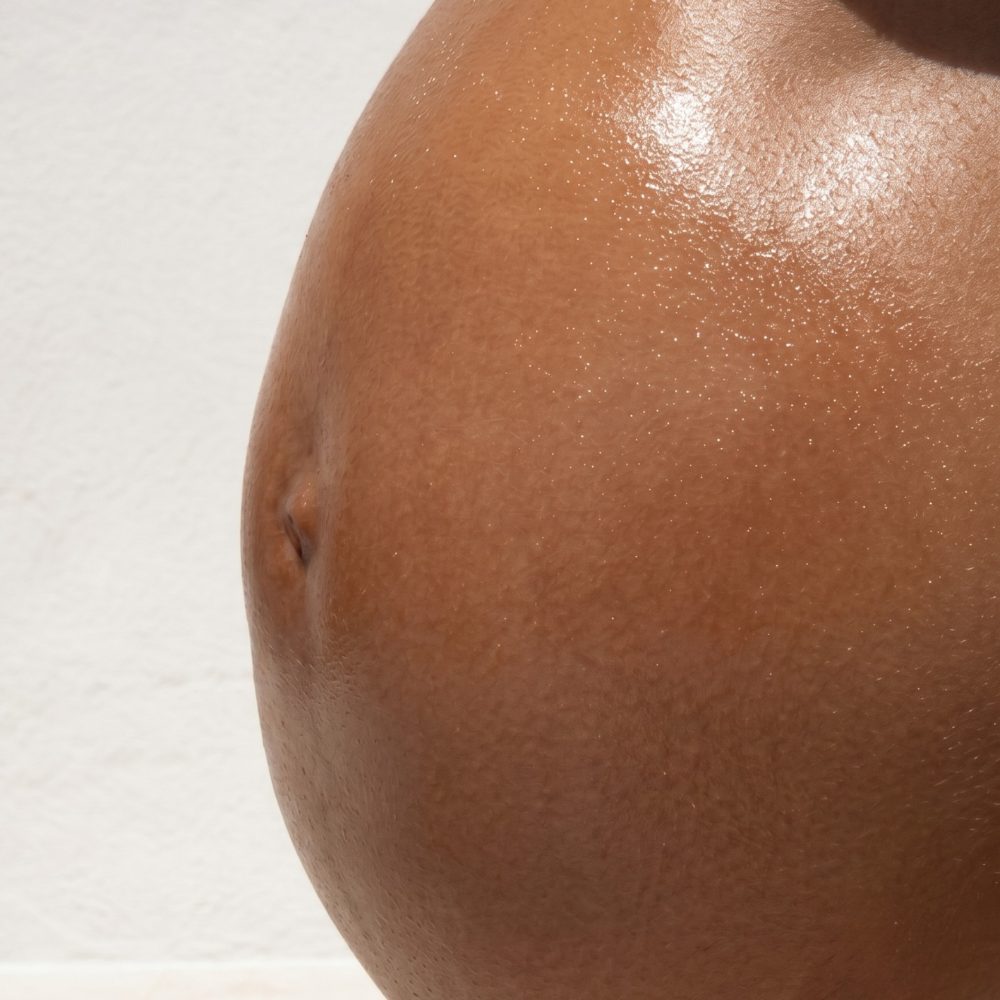 Pregnant belly with silky, glowing skin, after applying Bump Butter